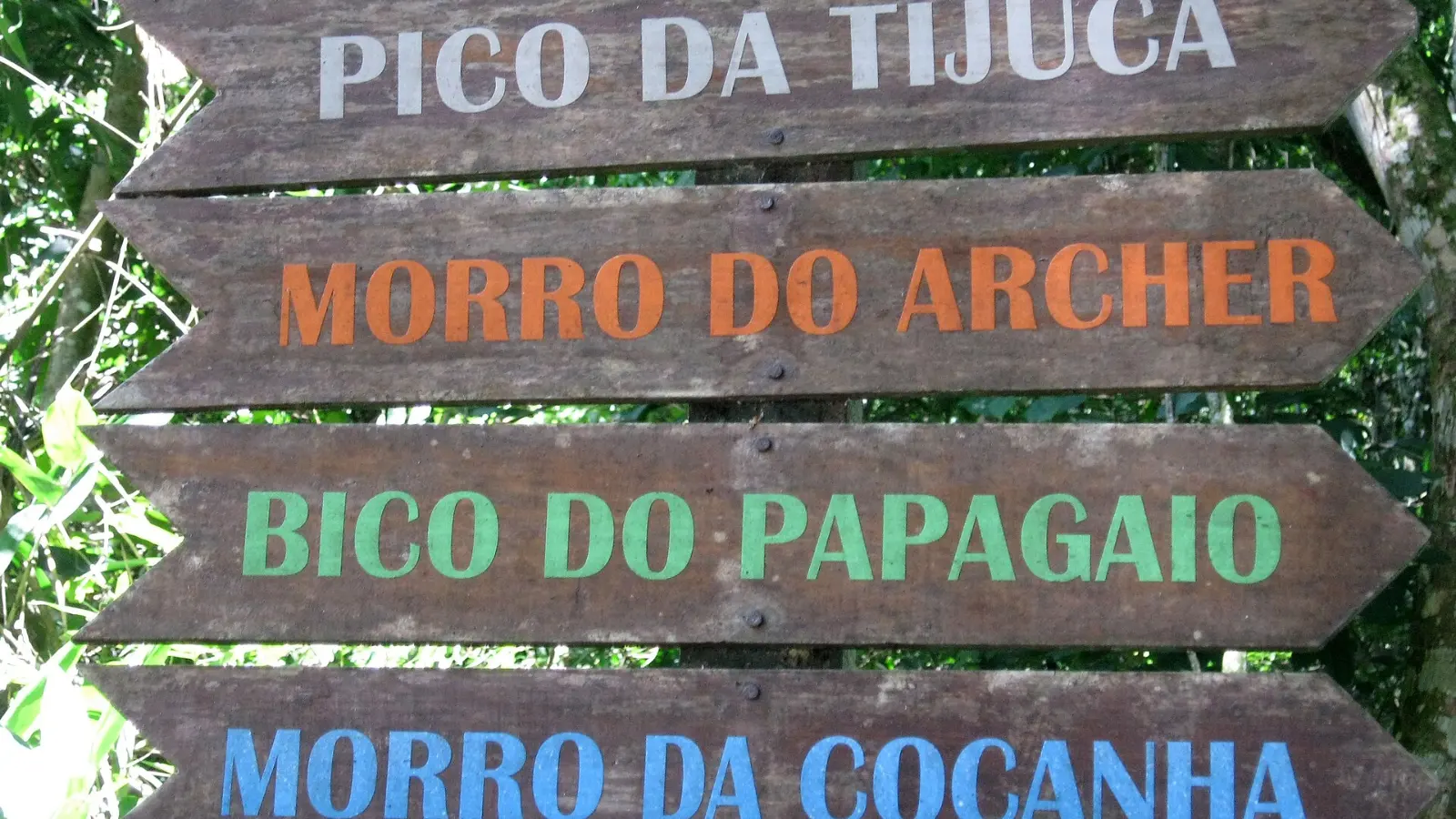 Cartel de madera en la Floresta da Tijuca que señala Pico da Tijuca, Morro do Archer, Bico do Papagaio y Morro da Cocanha